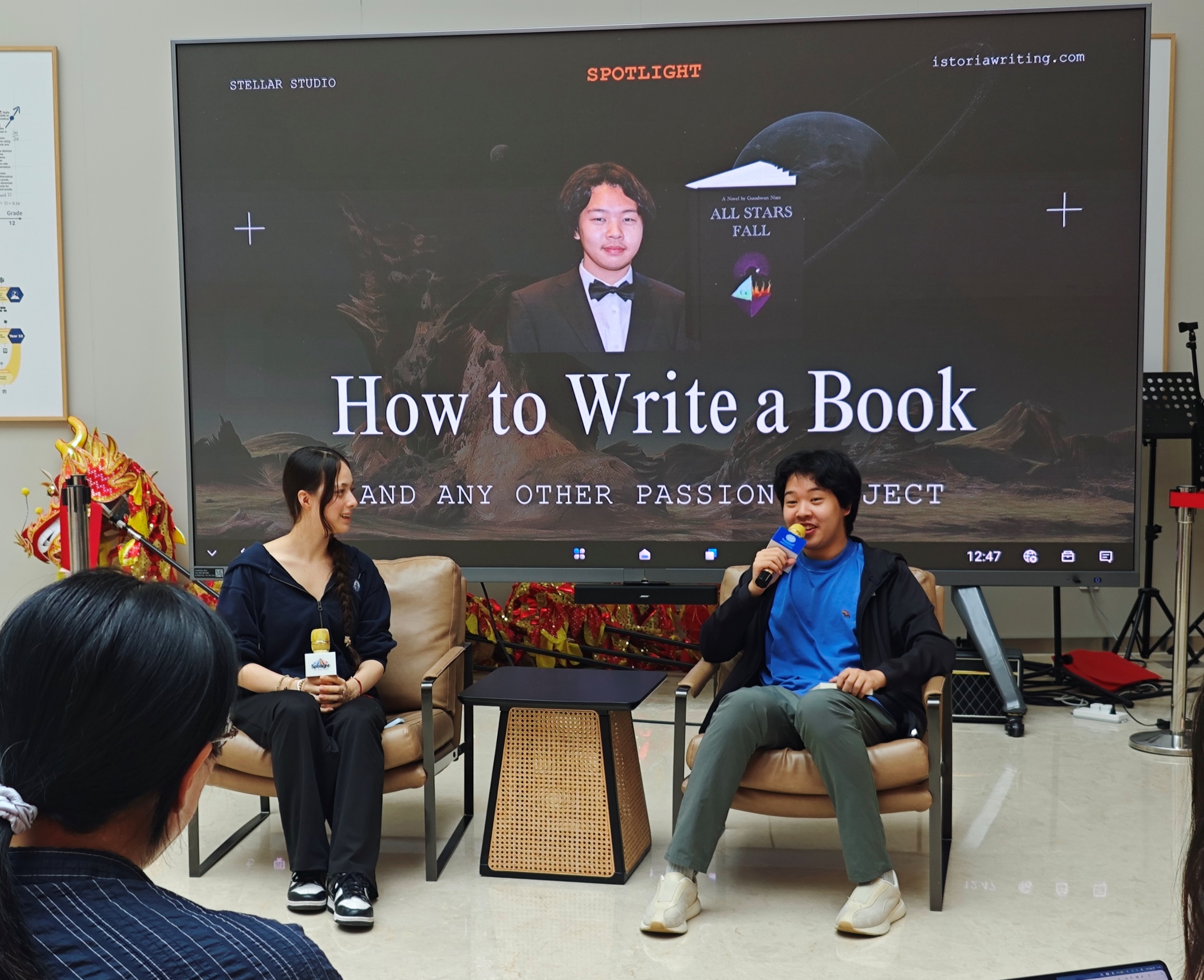 Guoshwan, seated at right, speaking about writing a novel at a SHSID Spotlight interview